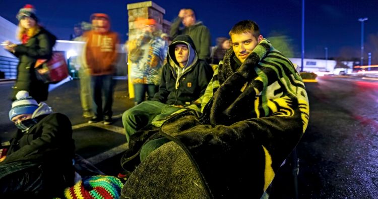 Dana Lamson, right, and Brennon Williams, of Saco, are among a long line of people waiting  to get into Best Buy at the Maine Mall before its midnight opening for Black Friday. Both had been waiting since 7 p.m. Ben McCanna/Staff Photographer