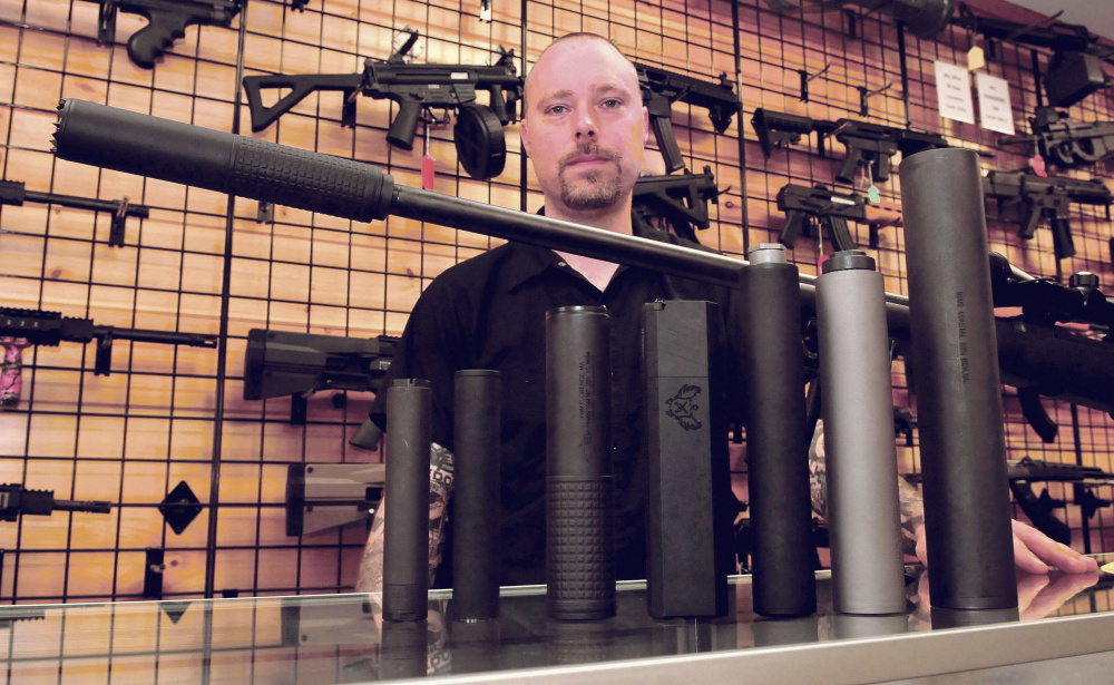 Adam Hendsbee, owner of A & G Shooting Supply in Fairfield, talks in his shop Wednesday about the variety of silencers that are now legal to have installed on firearms.