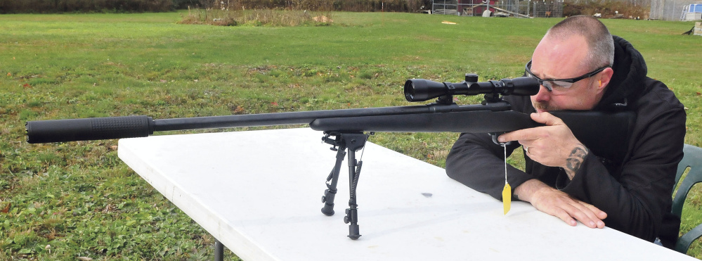 Adam Hendsbee takes aim while firing a .308-caliber rifle with a silencer attached on Wednesday.