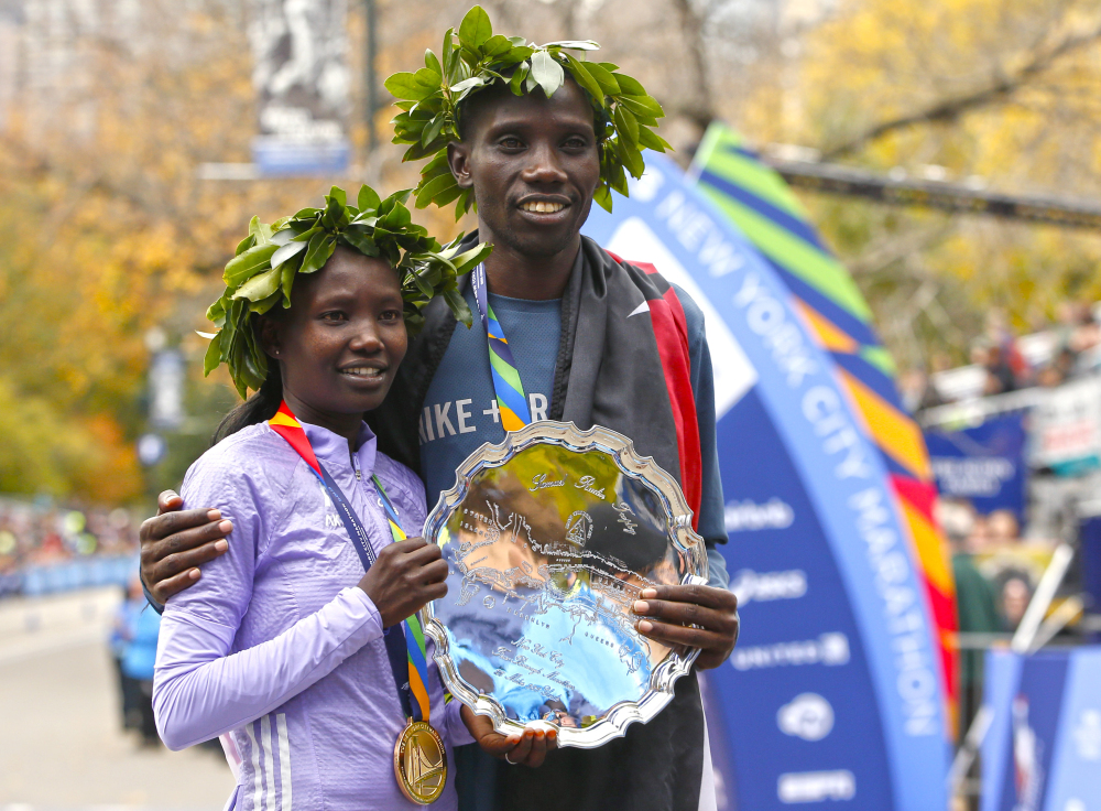 New York City marathon winners Mary Keitany and Stanley Biwott, both of Kenya, pose for photographers on the finish line of the the New York City Marathon on Sunday.