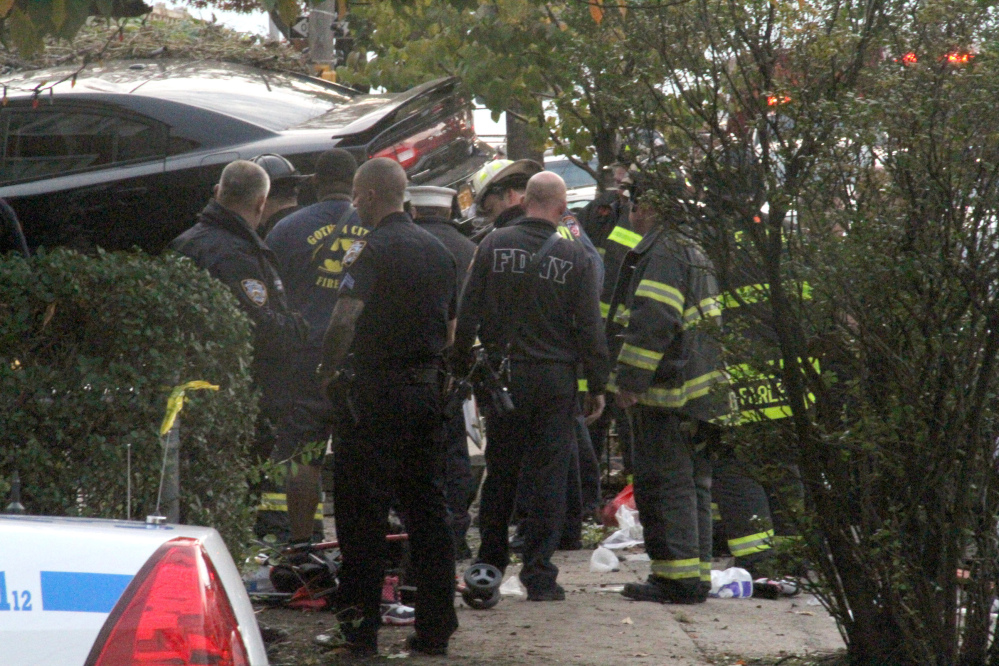 First responders examine an automobile after its driver lost control and plowed into a group of trick-or-treaters Saturday in New York.