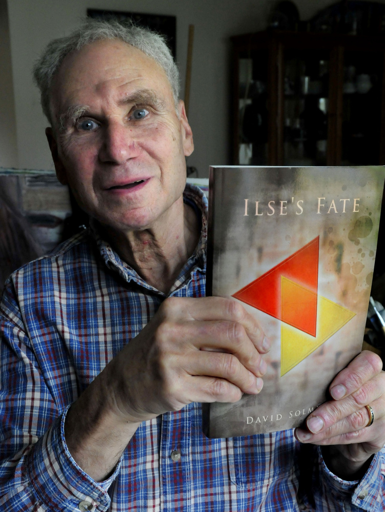 Author David Solmitz, of Waterville, holds a copy of his latest book, “Ilse’s Fate,” on Sunday.