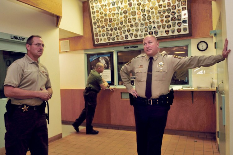 Franklin County Jail Administrator Major Douglas Blauvelt, left, and Sheriff Scott Nichols speak inside the entry lobby and control room to the jail in Farmington last week. Nichols said the return to a fully functioning county jail six months ago has gone well.