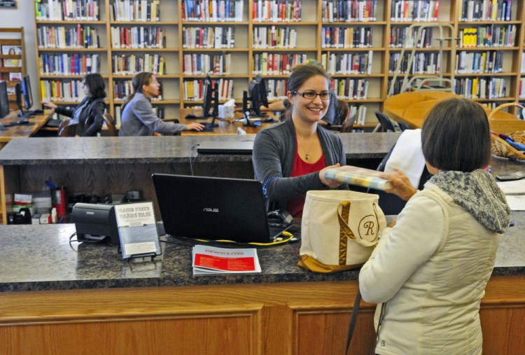 Library technician Katherine Webber, left, checks out books for Gail Ramsey on Friday at C.M. Bailey Public Library in Winthrop.
