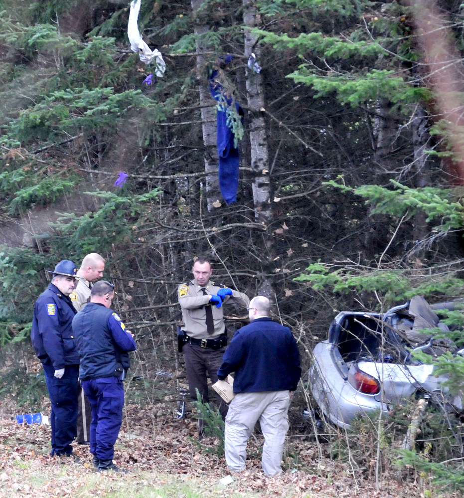 Items from the car driven by Robert Tucker went airborne and hang from trees as police collect evidence from the wreckage of Taylor’s car that crashed into trees off the Huff Road in Cornville during a police chase on Monday.