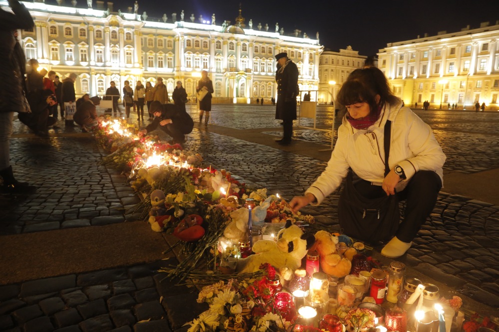 A woman lights a candle in memory of the plane crash victims at Dvortsovaya (Palace) Square in St.Petersburg, Russia, Tuesday.