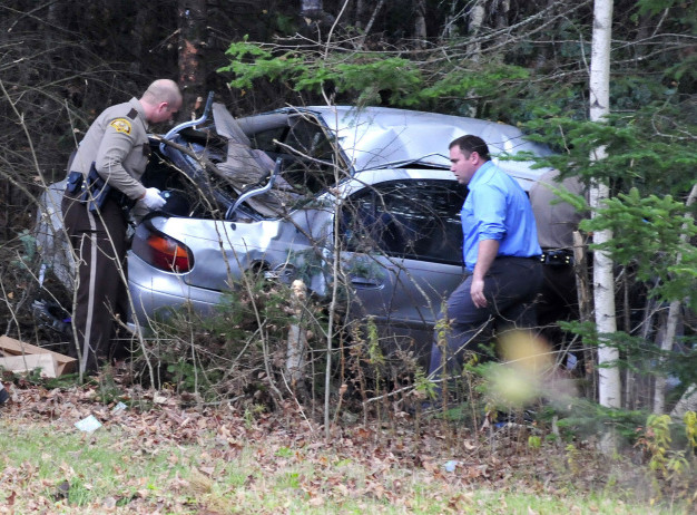 Somerset, state and Skowhegan police remove evidence from the wreckage of the car that Robert Tucker was driving during a police chase that started in Skowhegan and ended when the car left Huff Road in Cornville and crashed into trees on Monday.