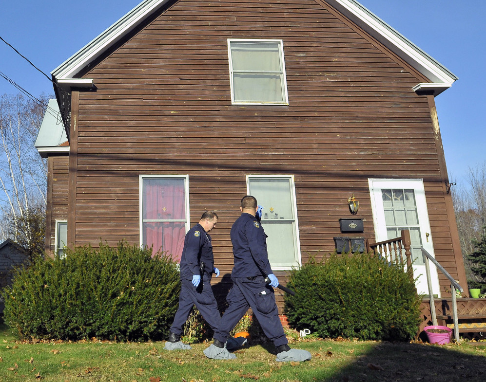 Maine State Police investigators on Thursday search the front of 41 Belgrade Road in Oakland, where three people were killed and the gunman killed himself.