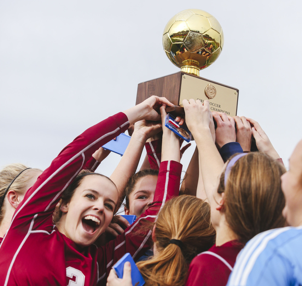Bangor High School girls’ soccer team hoists the state Class A Gold Ball after defeating Gorham 2-0 Saturday at Fitzpatrick Stadium.