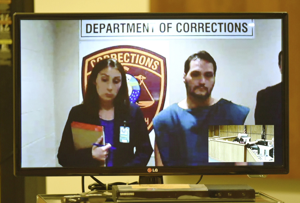 Matthew Dion is arraigned via video in June on double-murder charges at Manchester District Court in Manchester, N.H. Public Defender Aileen O’Connell is pictured at left.