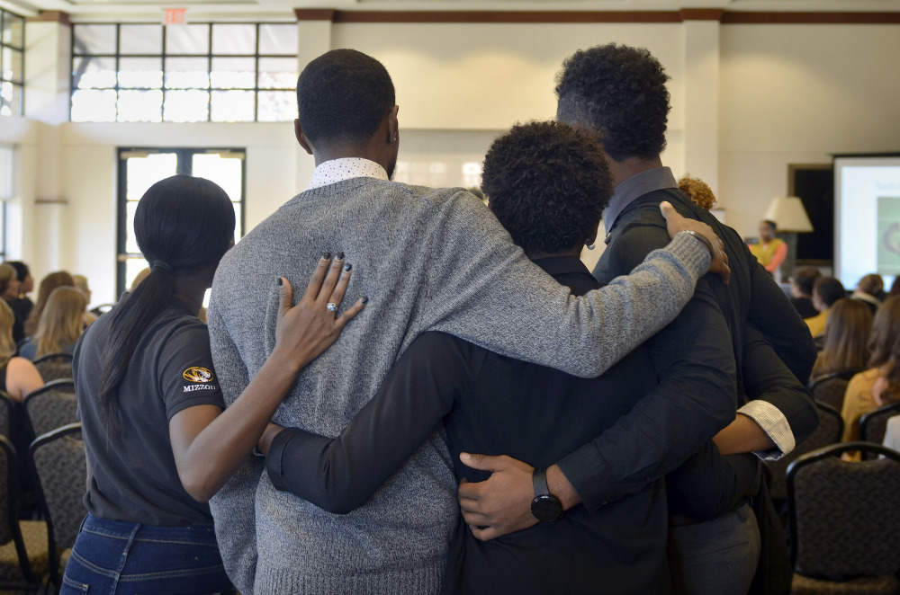 Members of the anti-racism and black awareness group Concerned Student 1950 embrace during a protest in the Reynolds Alumni Center on the University of Missouri campus in Columbia, Missouri, on Saturday.