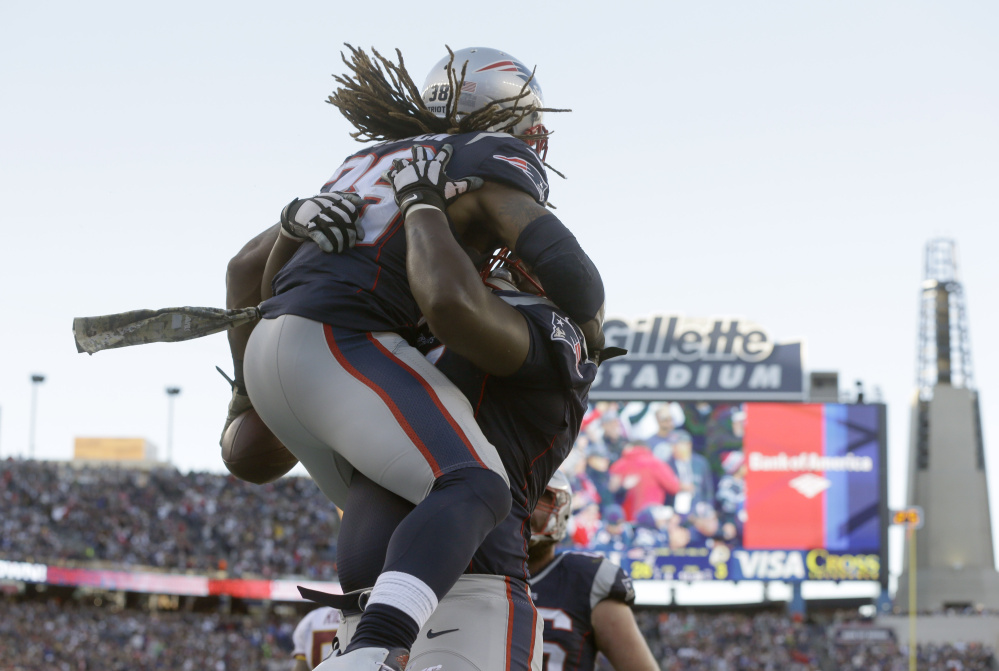 New England Patriots running back Brandon Bolden gets a lift after scoring a touchdown against Washington in the fourth quarter Sunday at  Foxborough, Massachusetts.
