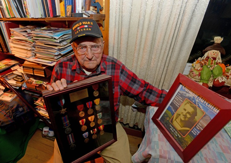 Real Cyr, a World War II veteran, poses with his war medals at his Winslow home on Wednesday.