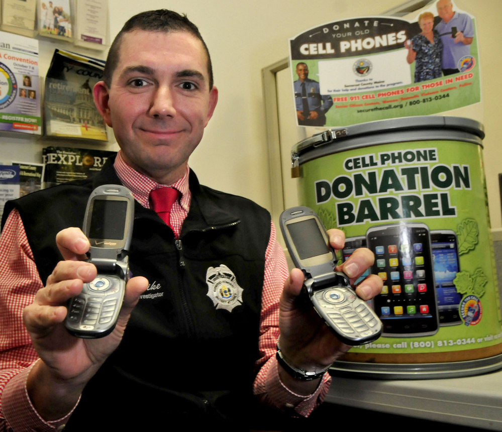 Mike Pike, a domestic violence investigator, holds cellphones that have been cleared of information and will be available to victims in Somerset County to use for 911 emergency services.
