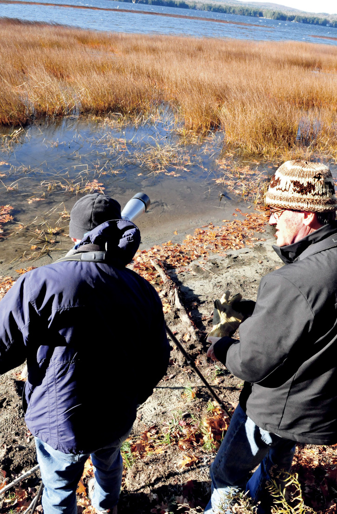 Phil Downes, left, and Louise Bevier prepare to look for waterfowl in the marshy area of North Pond in Smithfield on Sunday.
