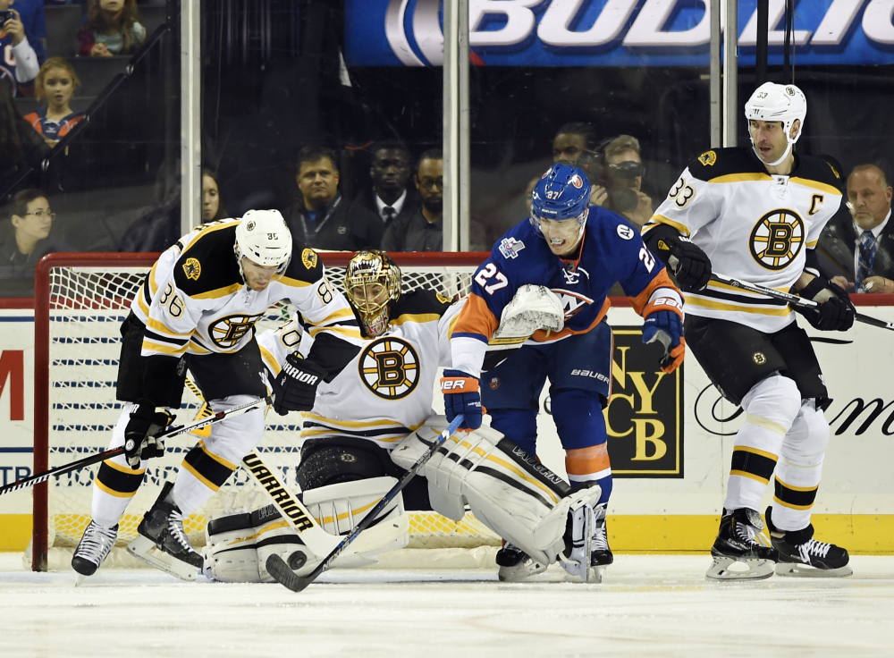 Boston’s Kevan Miller (86), goalie Tukka Rask (40) and Zdeno Chara (33) defend against New York Islanders’ Anders Lee (27) during the first period Sunday in New York.