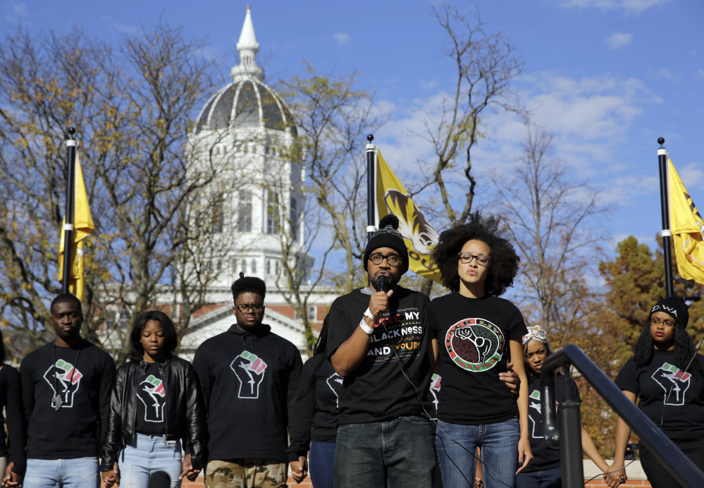 Jonathan Butler, front left, addresses a crowd at the University of Missouri in Columbia after it was announced that university system President Tim Wolfe would resign Monday. Butler ended his hunger strike as a result of the resignation.