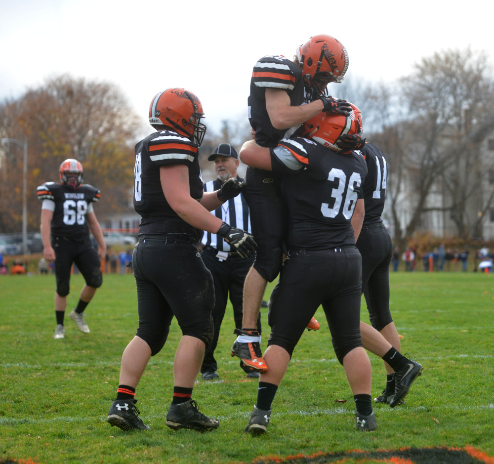 Winslow running back Nate St. Amand (22) jumps into the arms of teammate Kenny Rickard (36) after the Raider scored a touchdown Saturday against Mt. Desert Island.