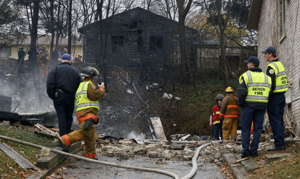 Police and firefighters work at the scene where authorities say a small business jet crashed into an apartment building in Akron, Ohio, Tuesday.