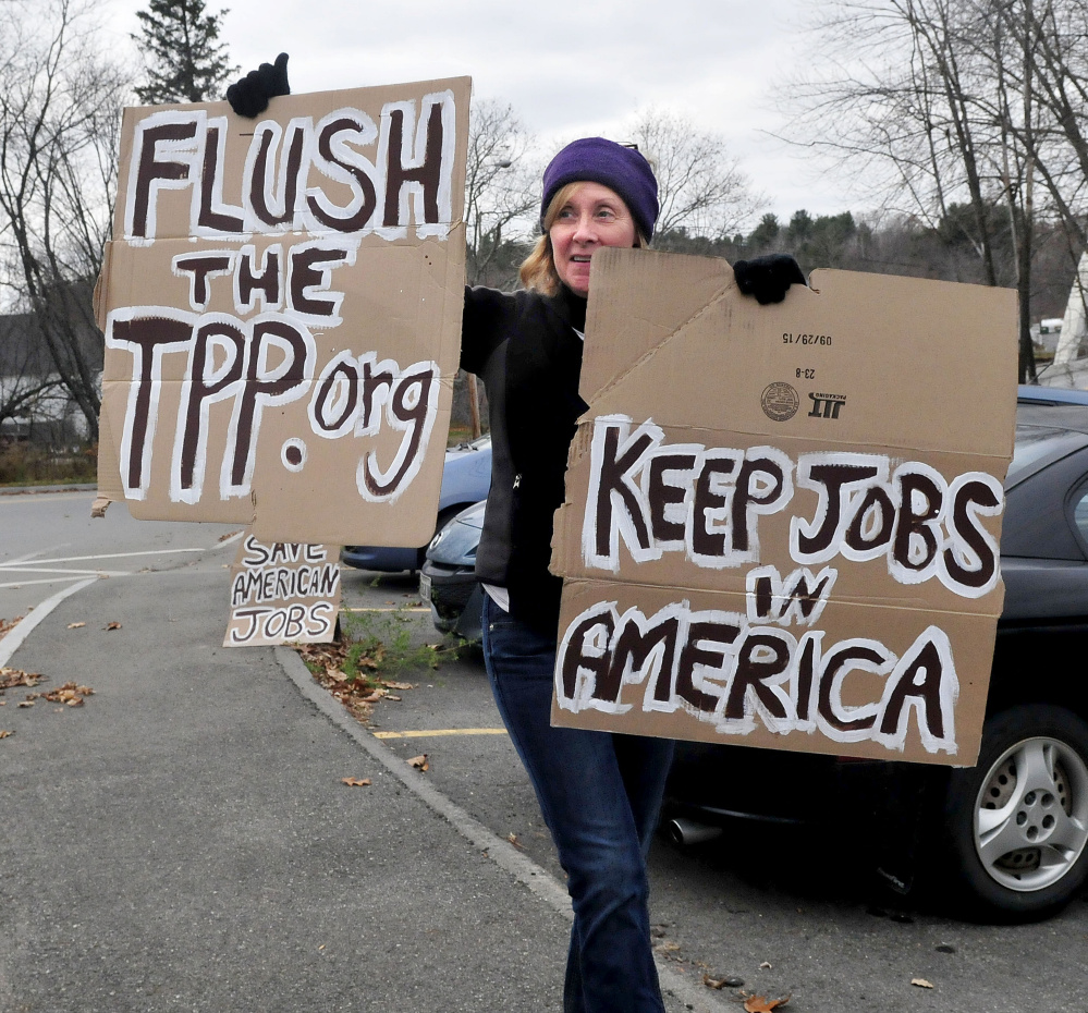 Kim Cormier pickets against Trans Pacific Trade outside the New Balance company as workers exit in Norridgewock on Wednesday.