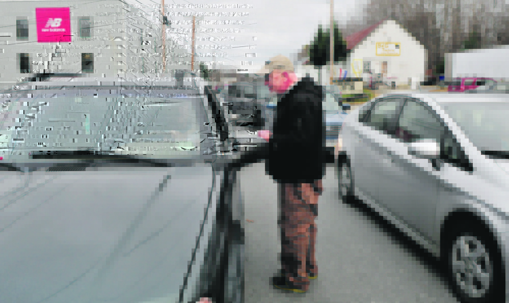 Clark Miller hands out papers with numbers to call to urge the state’s congressional delegation to vote against the Trans Pacific Partnership as workers at New Balance in Norridgewock leave for the day Wednesday.