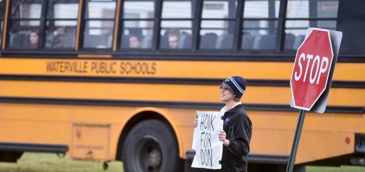 A Waterville Senior High School student stands at the exit to the high school with a sign in support of Waterville Senior High School principal, Don Reiter, at a rally after school Friday. Reiter, accused of propositioning a student, has been on administrative leave since Sept. 1.