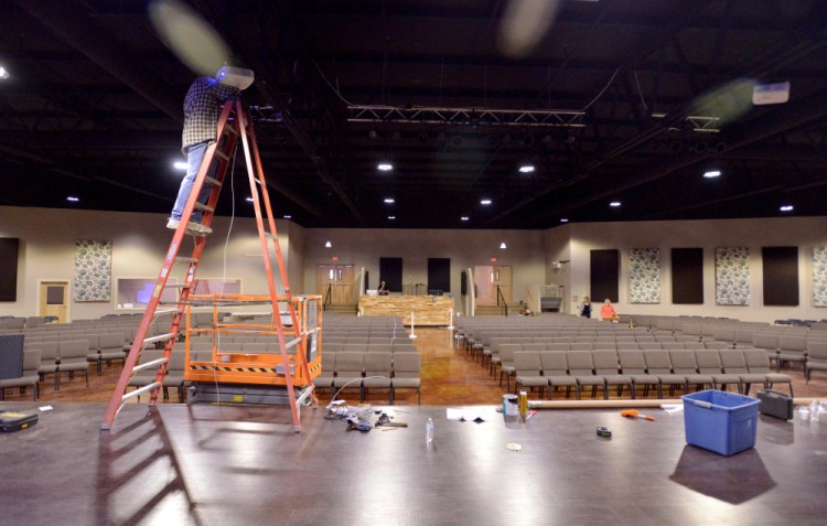 Bill Wade, assistant pastor at Centerpoint Community Church, finishes wiring the stage in the worship auditorium at CenterPoint Church in Waterville. The former Sparetime Recreation bowling alley was renovated for the church, which is hosting a concert Saturday night and its first service in the building  Sunday.