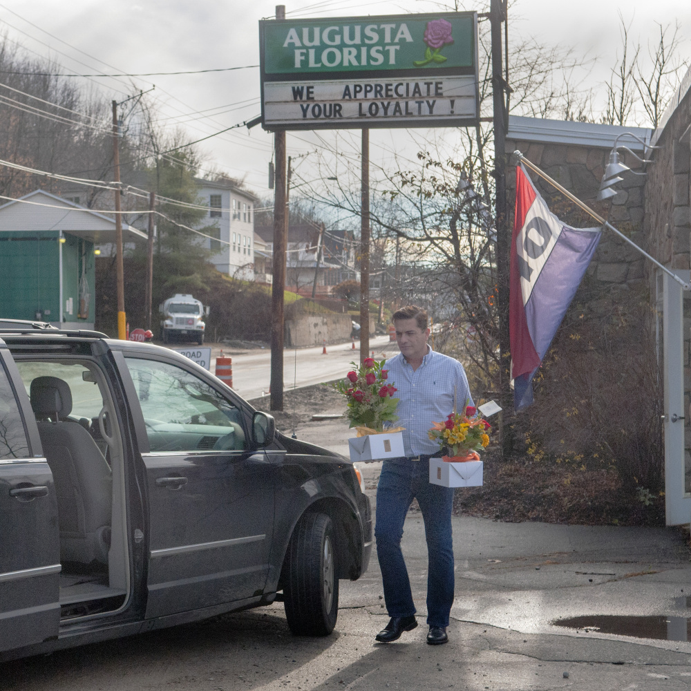 Augusta florist Scott O’Brien carries flowers out to his van on Mount Vernon Avenue in Augusta to make deliveries on Friday. Construction is winding down for the season.