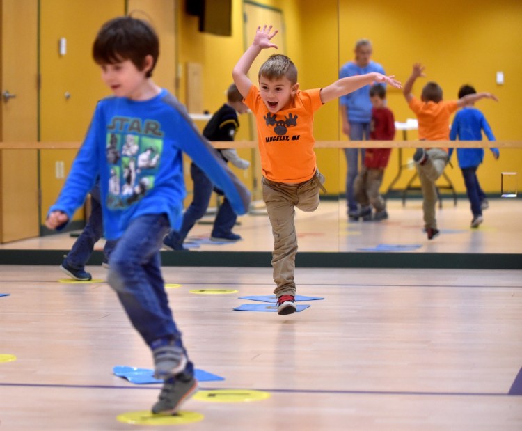 Keagan Talbert, left, and Ryan Dugan, back, play chocolate river in which they have to leap from circle to circle to get across the invisible river during the Children in Action after school program that involves physical and nutritional activities at the Rangeley Health and Fitness Center in Rangeley Thursday.