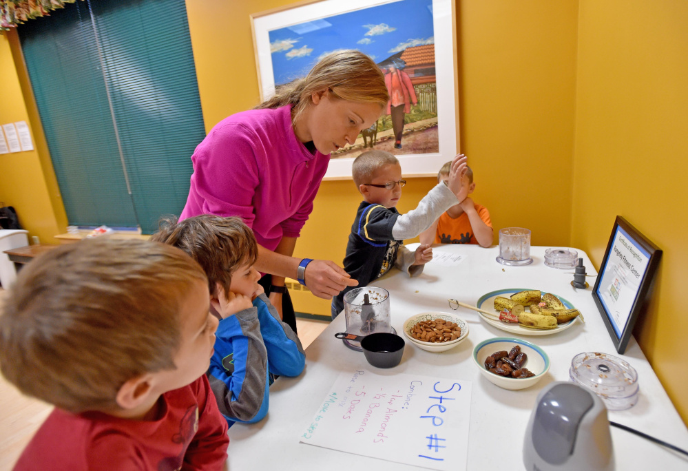 Lindsay Richards, fitness director and program coordinator at Rangeley Health and Fitness, helps Eben Laliberte, 5, far left, Keagan Talbert, 5, second from left, Chase Bachelor, 5, second from right, and Ryan Dugan, 5, create granola bars to mold into shapes at the Children in Action after school program at Rangeley Fitness and Health Center in Rangeley Thursday.