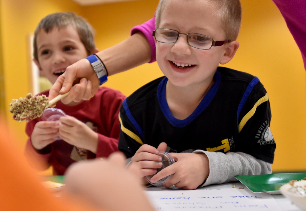 Chase Bachelor, right, and Eben Laliberte, left, smile as they mold their granola buddy into different shapes for snacks later during the Children in Action after-school program at the Rangeley Health and Fitness Center in Rangeley Thursday.