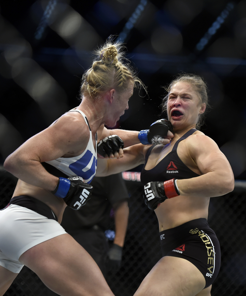 Holly Holm, left, punches Ronda Rousey during their UFC 193 bantamweight title fight Sunday in Melbourne, Australia. Holm pulled off a stunning upset victory over Rousey, knocking out the women’s bantamweight champion in the second round with a powerful kick to the head.