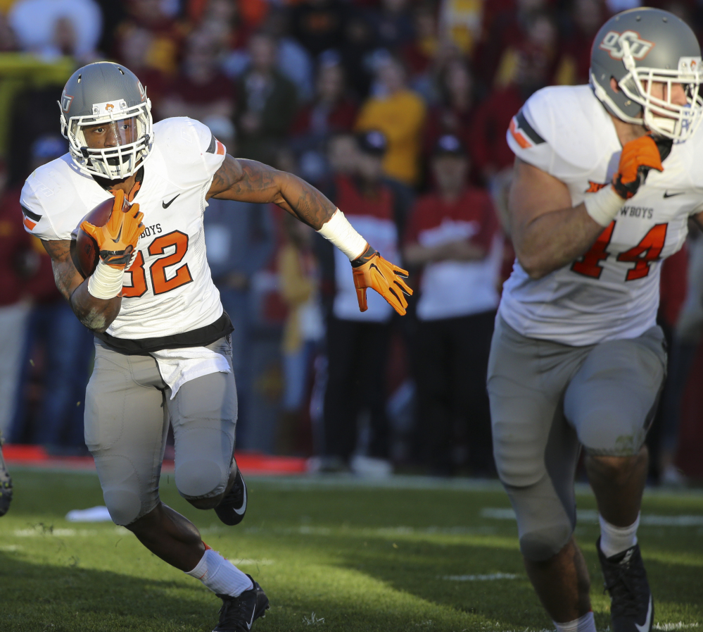 Oklahoma State running back Chris Carson runs for a touchdown during the first half against Iowa State on Saturday in Ames, Iowa. The Cowboys moved up to No. 4 after winning 35-31.