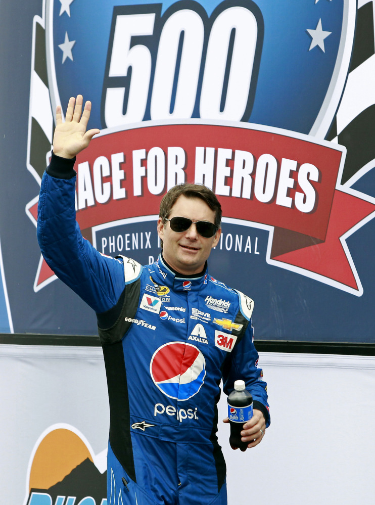 Series points leader Jeff Gordon waves to the crowd during driver introductions before the NASCAR Sprint Cup Series race Sunday at Phoenix International Raceway in Avondale, Ariz. The race was delayed by rain.