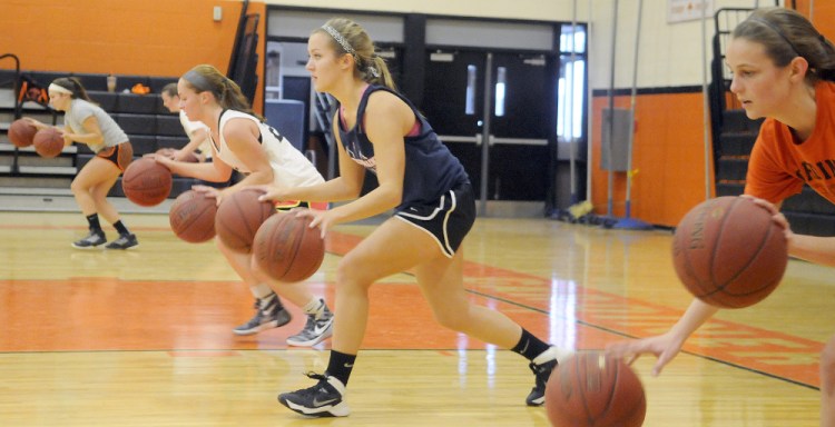 The Gardiner Area High School girls basketball team does dribbling drills at the first day of tryouts Monday in Gardiner.