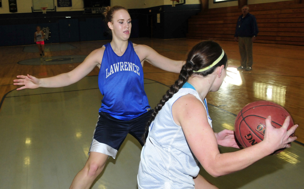 Lawrence’s Nia Irving, left, blocks Emily Tozier during practice Monday in Fairfield. Monday marked the first day winter sports teams could practice.