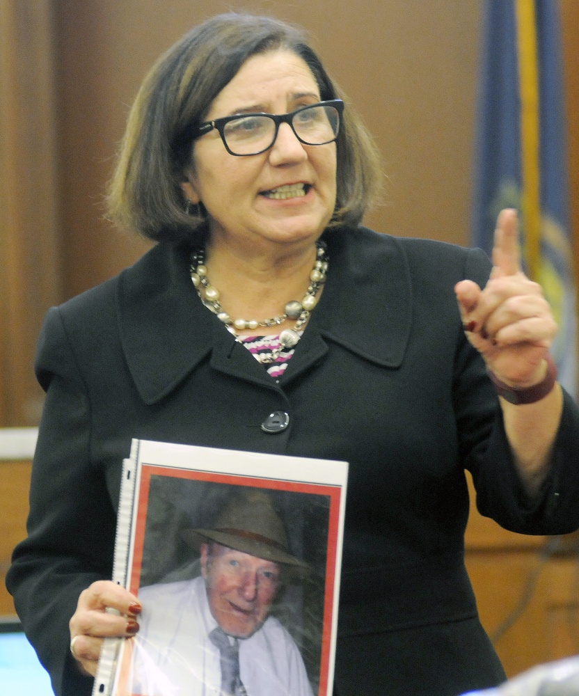 Assistant Attorney General Leane Zainea holds a photo of murder victim Aurele Fecteau Wednesday during closing arguments of the trial of Roland J. Cummings in Augusta.
