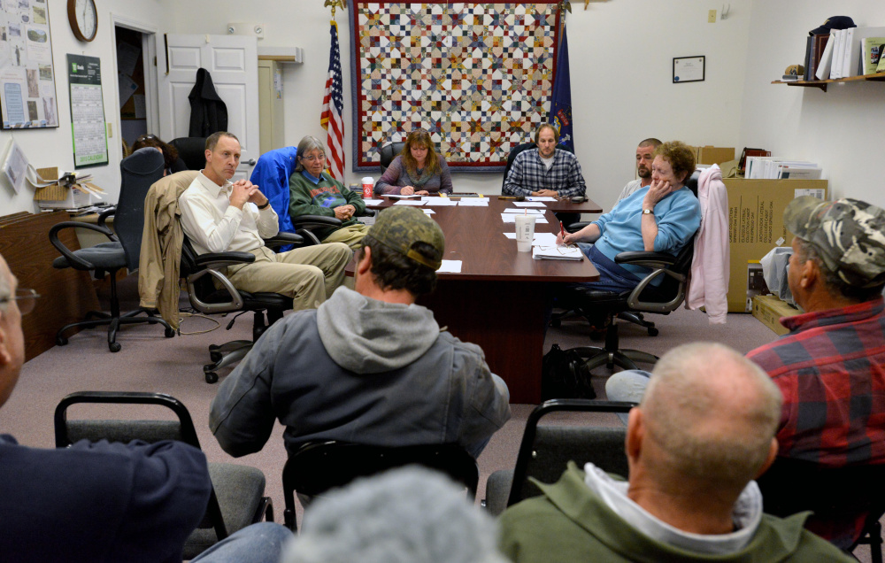 Norridgewock selectmen sit at a table as residents fill the room for an open session meeting at the town office in Norridgewock on Wednesday