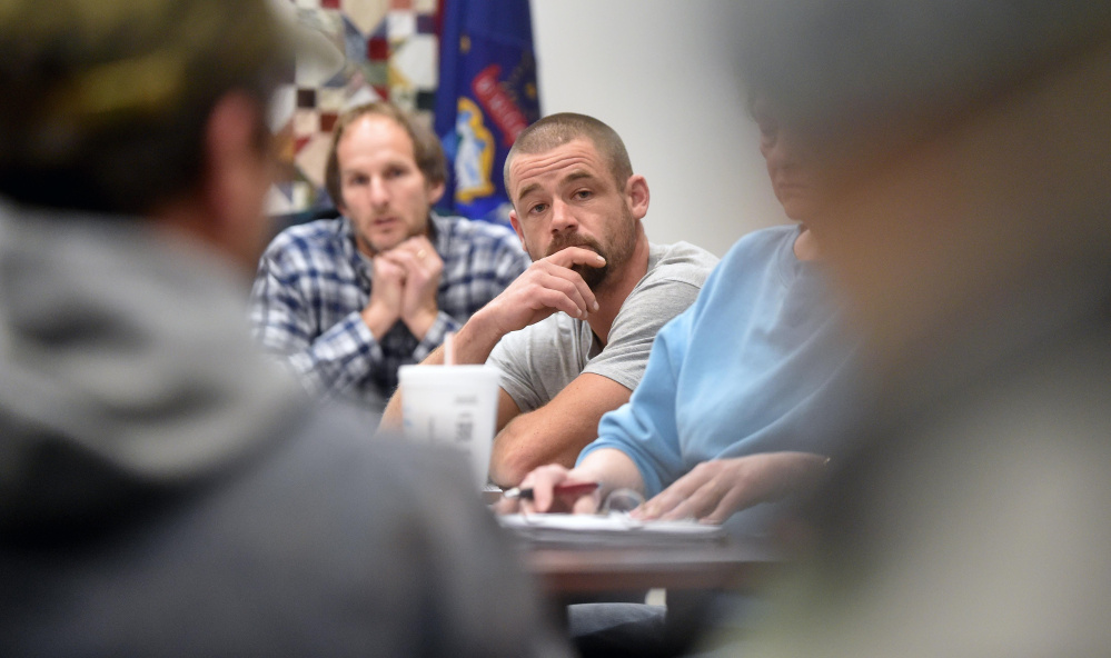 Ron Frederick, chairman of the board of selectmen, left background, and Matt Everett, vice-chairman, center, listen as town residents voice concerns during an open session at the town office in Norridgewock on Wednesday regarding what they would like to see in the next town manager.