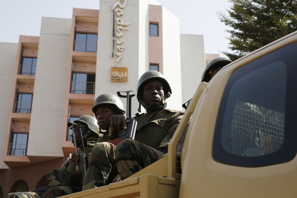 Soldiers from the presidential guard patrol outside the Radisson Blu hotel in Bamako, Mali, on Saturday in anticipation of the President’s visit.  Malian security forces were hunting “more than three” suspects after a brazen assault on a luxury hotel in the capital that killed 20 people plus two assailants, an army commander said.