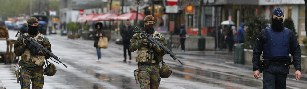 Belgian soldiers and a police officer patrol in central Brussels, Saturday, after security was tightened in Belgium following the fatal attacks in Paris.
