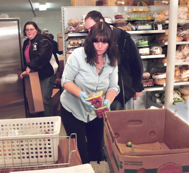 Care and Share Food Closet volunteers prepare to fill a cooler with vegetables at the Farmington group’s building on Wednesday. From left are Heather Hodsdon, Lee Spaulding and Ann Flanders.