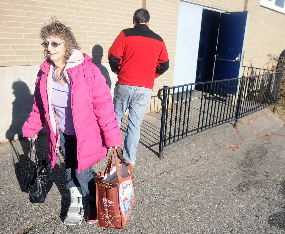 Peggy Taylor exits the gymnasium at St. Michael School in Augusta on Monday with a bag full of groceries.