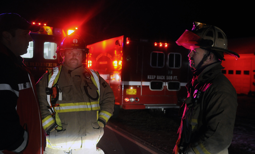 Pittston Fire Chief Jason Farris, right, and Lt. Mike Flanders, center, speak Monday with Gardiner Fire Dept. Captain Pat Saucier at a fatal accident on Route 194 in Pittston.