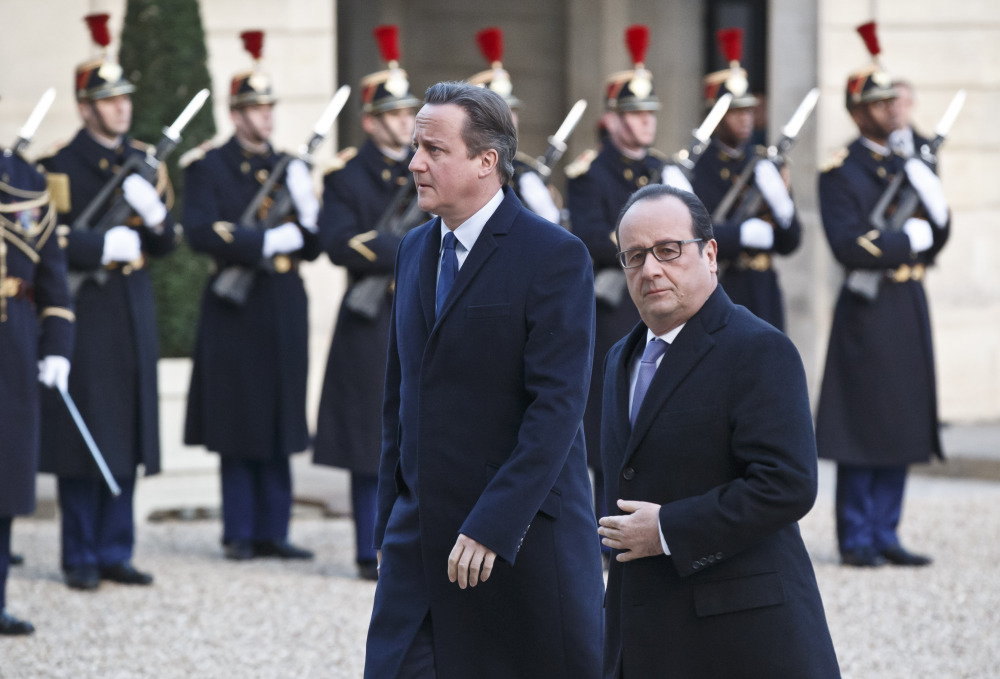 Britain’s Prime Minister David Cameron, left, and France’s President Francois Hollande arrive at the Elysee Palace in Paris, Monday.