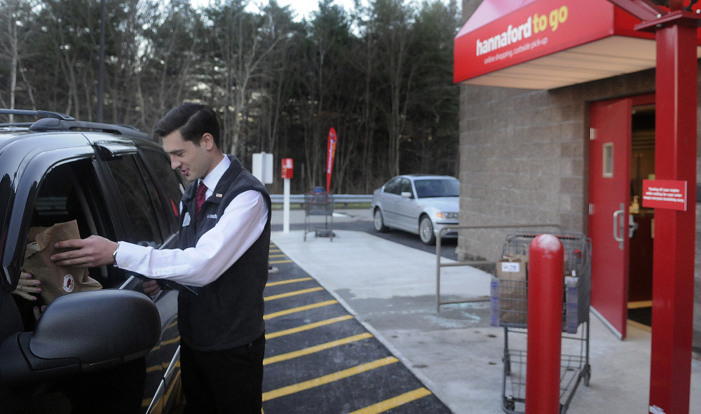Hannaford employee Matt Pazdziorko hands customer Priscilla Zarella, of Readfield, items she ordered Monday from the Hannaford on the Whitten Road in Augusta at the new drive up delivery spot. For a $5 service fee if the order is less than $125, customers can order items and pick them up outside the store. If the order is more than $125, the service is free.