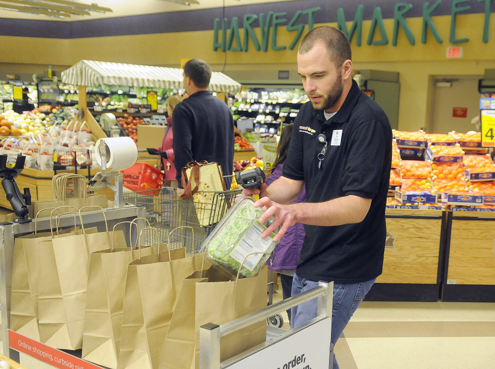 Hannaford employee Joe Stanhope fulfills an order Monday for the new Hannaford To Go at the Whitten Road in Augusta. For a $5 service fee if the order is less than $125, customers can order items and pick them up outside the store. If the order is more than $125, the service is free.