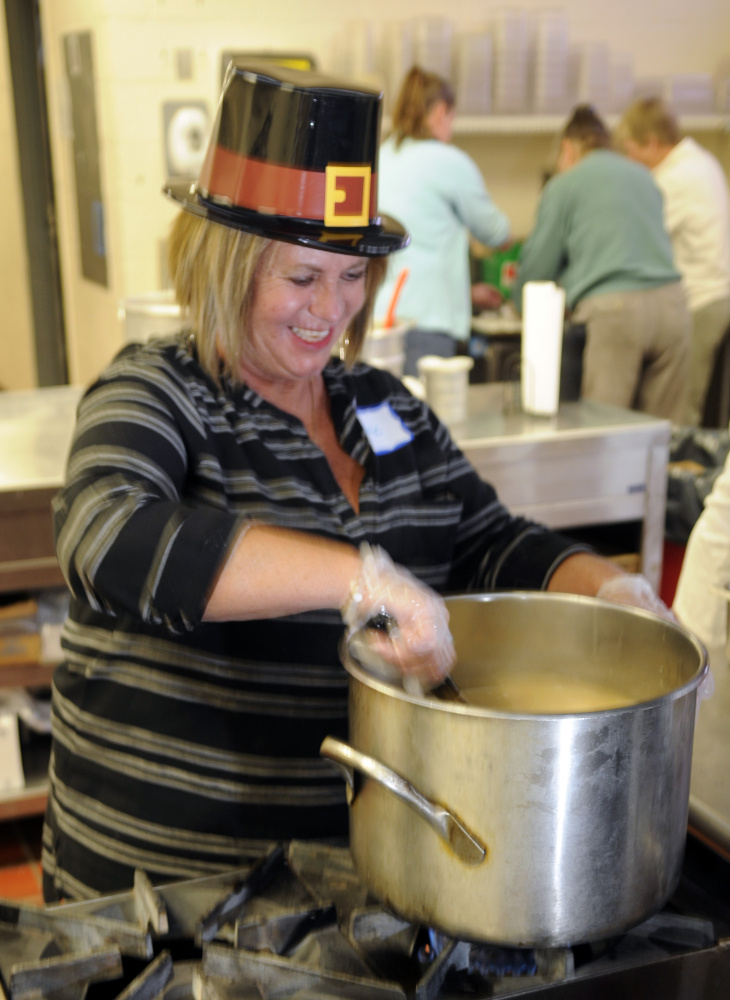 Cathie Hinds stirs the gravy pot as volunteers prepare for the community Thanksgiving dinner put on by the Augusta Valley Scottish Rite Masons at Gardiner Area High School on Thursday.