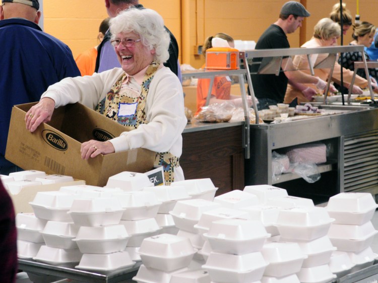 Shirley Everhart laughs with other volunteers as they prepare boxes of pie for meals that will be delivered from the community Thanksgiving dinner put on by the Augusta Valley Scottish Rite Masons at Gardiner Area High School on Thursday.