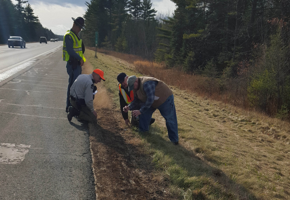 State police, investigators from the State Fire Marshal’s Office and rangers from the Maine Forst Service investigate the scene of one of the six intentionally set fires along Interstate 95 Friday morning.